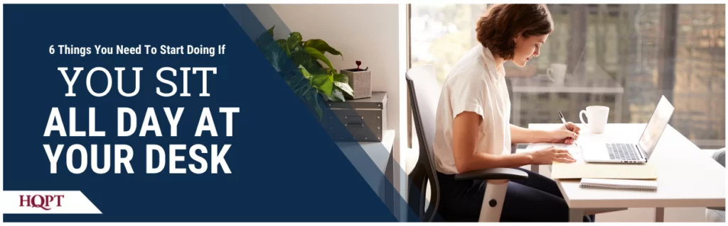 Woman sitting at desk with a computer and notepad
