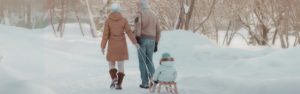 mother and father pulling child in sled